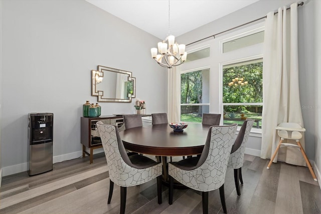 dining area featuring wood-type flooring and a chandelier