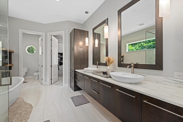 bathroom featuring vanity, toilet, a bidet, and tile patterned floors