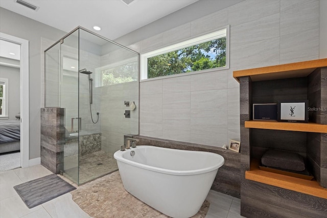 bathroom with tile walls, independent shower and bath, and tile patterned flooring