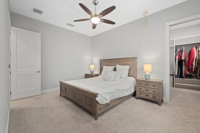 bedroom featuring light colored carpet, ceiling fan, and a closet