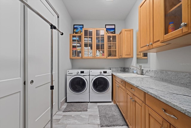 washroom with cabinets, sink, and washing machine and dryer