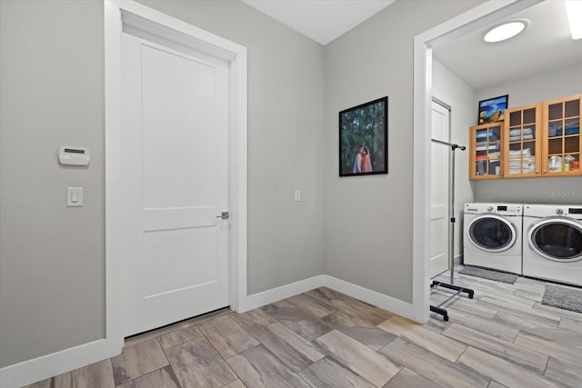 washroom with light hardwood / wood-style floors and washing machine and dryer