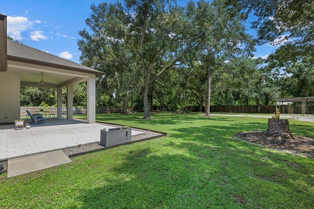 view of yard with ceiling fan and a deck