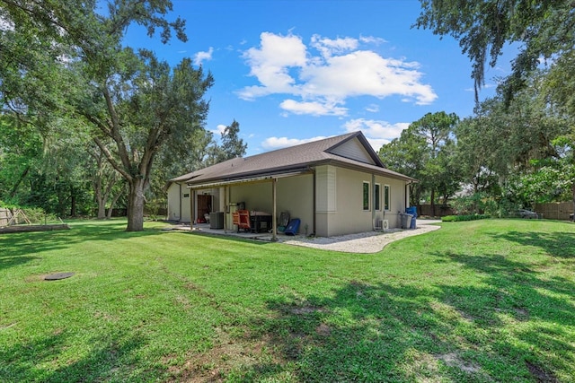 rear view of house with a lawn and a patio area