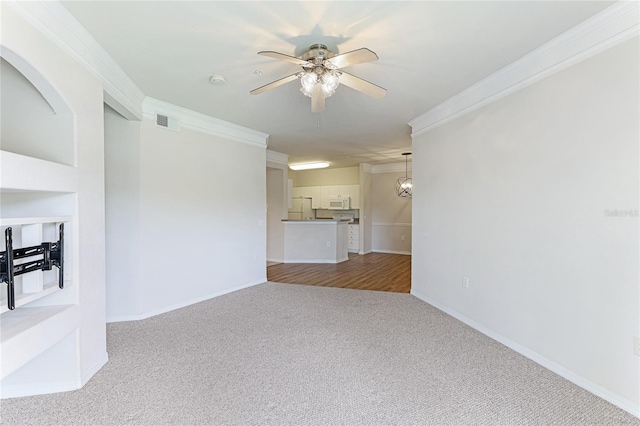 unfurnished living room with visible vents, ornamental molding, carpet flooring, ceiling fan, and baseboards