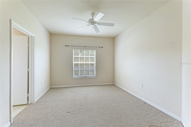 unfurnished room featuring ceiling fan, baseboards, and light colored carpet