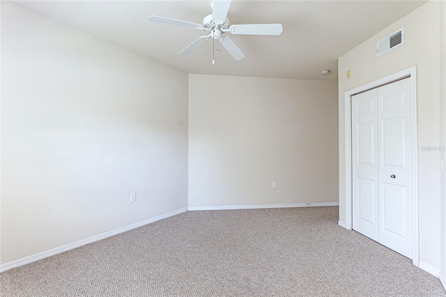 unfurnished bedroom featuring baseboards, visible vents, a ceiling fan, and light colored carpet