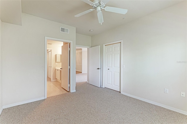 unfurnished bedroom featuring a closet, visible vents, light carpet, and baseboards