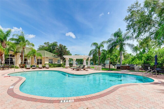 view of swimming pool featuring a patio and a pergola