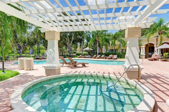 view of swimming pool with a community hot tub, a pergola, and a patio