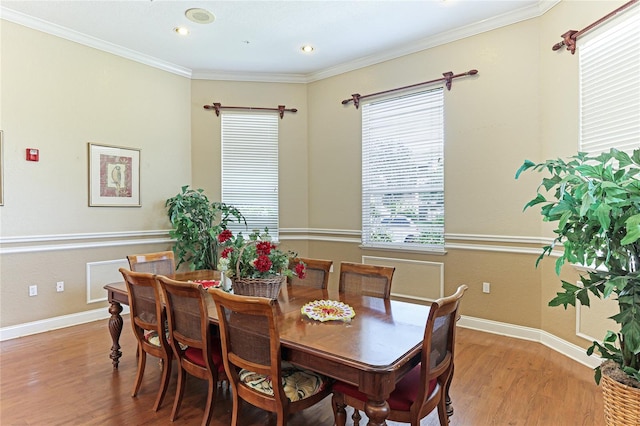 dining room featuring plenty of natural light, hardwood / wood-style flooring, and crown molding