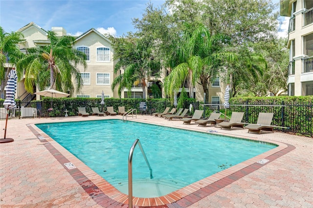 community pool featuring a patio area and fence