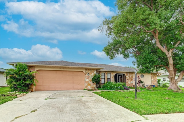 ranch-style home with a garage, concrete driveway, a front lawn, and stone siding