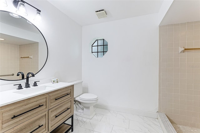 bathroom with tiled shower, toilet, and vanity