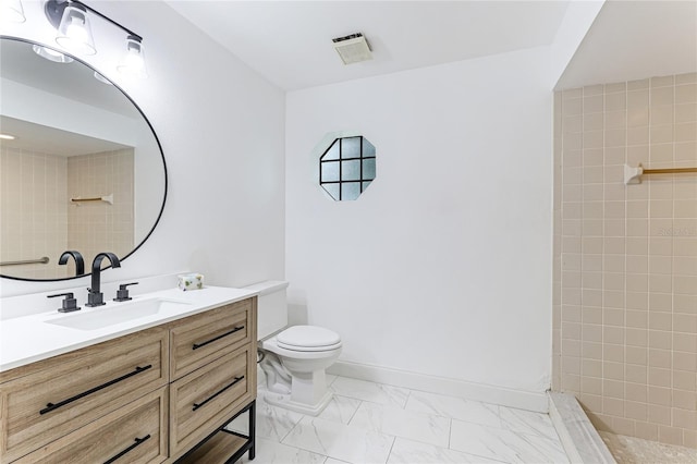 full bath with vanity, baseboards, a tile shower, toilet, and marble finish floor