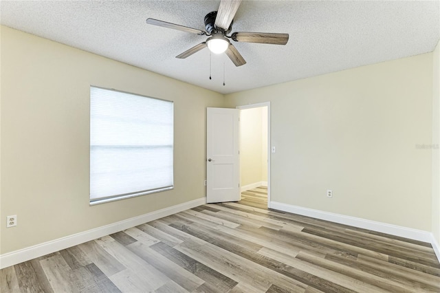 unfurnished room featuring a textured ceiling, a wealth of natural light, ceiling fan, and light hardwood / wood-style floors