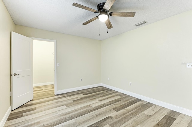 spare room featuring a textured ceiling, light hardwood / wood-style flooring, and ceiling fan