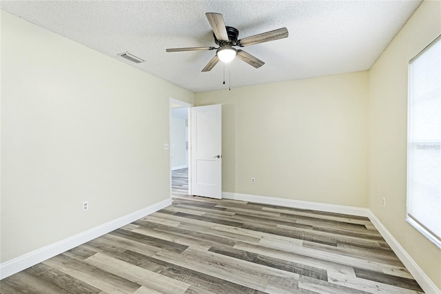 empty room featuring a textured ceiling, ceiling fan, and light hardwood / wood-style floors