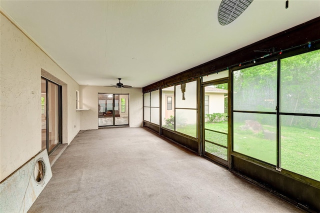 unfurnished sunroom featuring ceiling fan