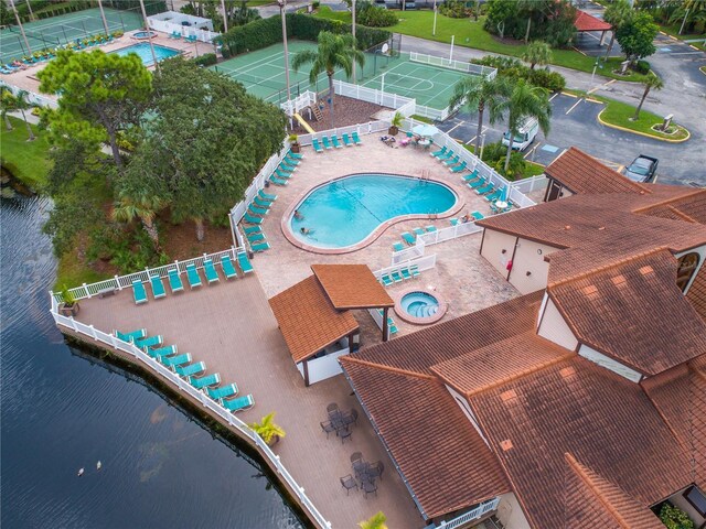 view of swimming pool featuring a water view and a patio