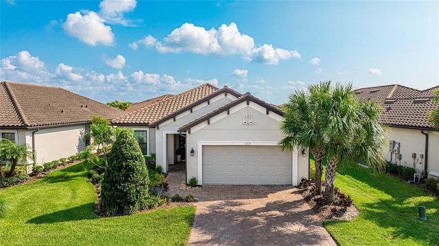 mediterranean / spanish-style house with a garage and a front lawn