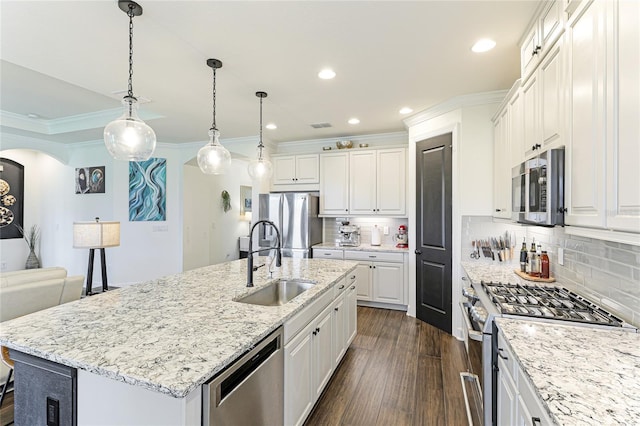 kitchen with white cabinetry, sink, light stone counters, stainless steel appliances, and a center island with sink