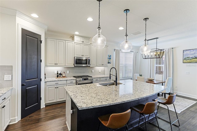 kitchen with white cabinetry, appliances with stainless steel finishes, a kitchen island with sink, and sink