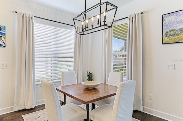 dining room with a notable chandelier, dark hardwood / wood-style flooring, and ornamental molding