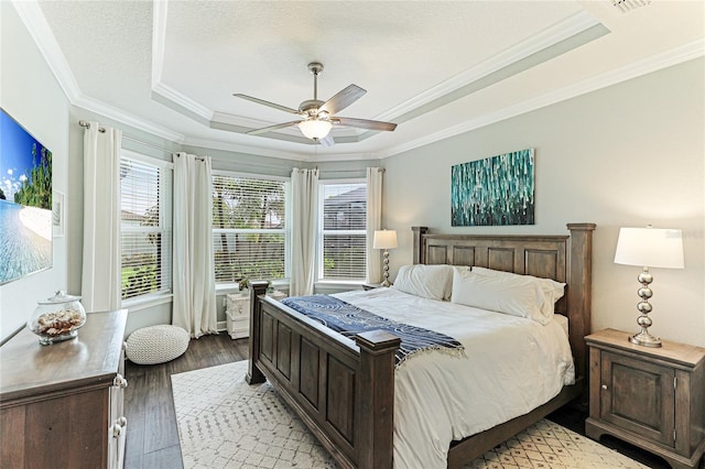 bedroom with a raised ceiling, ornamental molding, a textured ceiling, and light hardwood / wood-style floors