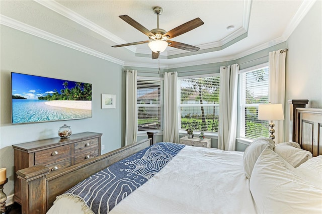 bedroom featuring crown molding, ceiling fan, a raised ceiling, and a textured ceiling