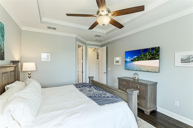 bedroom with ceiling fan, dark hardwood / wood-style flooring, ornamental molding, and a tray ceiling