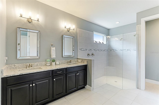 bathroom featuring a tile shower, vanity, and tile patterned flooring