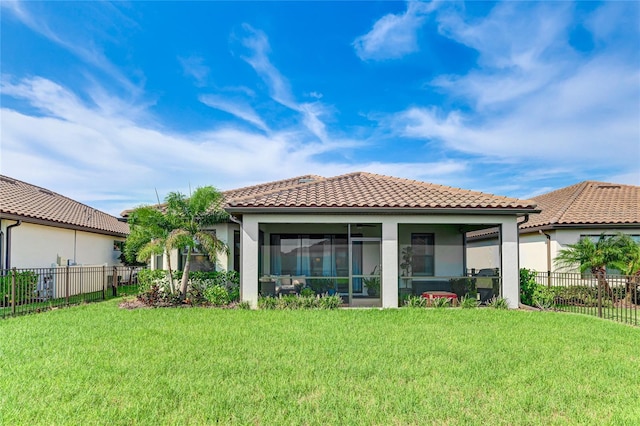 back of property featuring a sunroom and a lawn