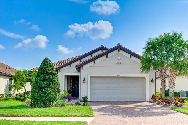 view of front of house with a garage, a front yard, and cooling unit