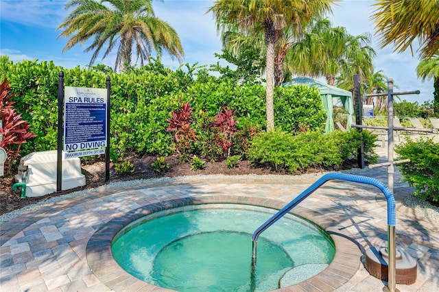 view of swimming pool with a hot tub