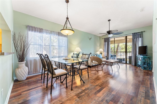 dining room featuring dark wood-style flooring, a ceiling fan, and baseboards