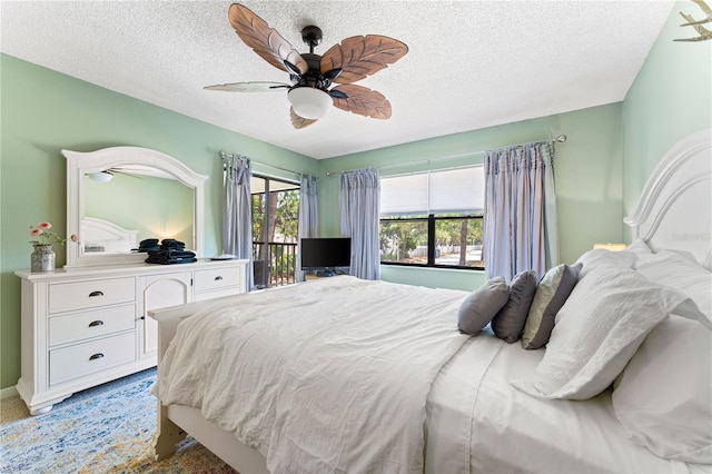 carpeted bedroom with access to outside, a textured ceiling, and ceiling fan