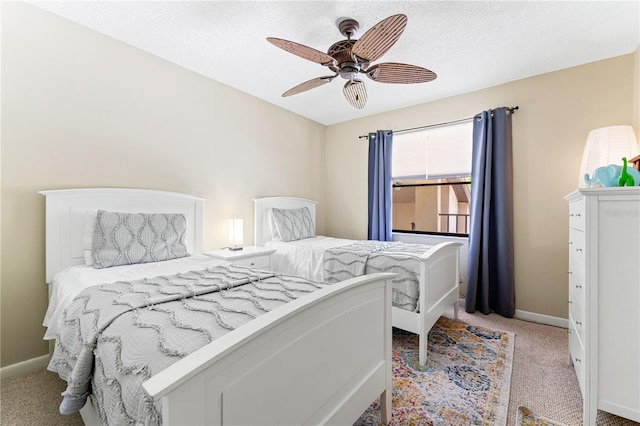 bedroom featuring baseboards, ceiling fan, a textured ceiling, and light colored carpet