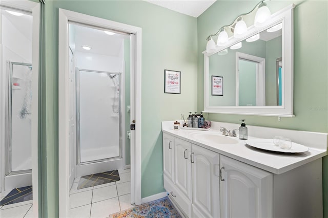 full bathroom with a stall shower, tile patterned flooring, vanity, and baseboards