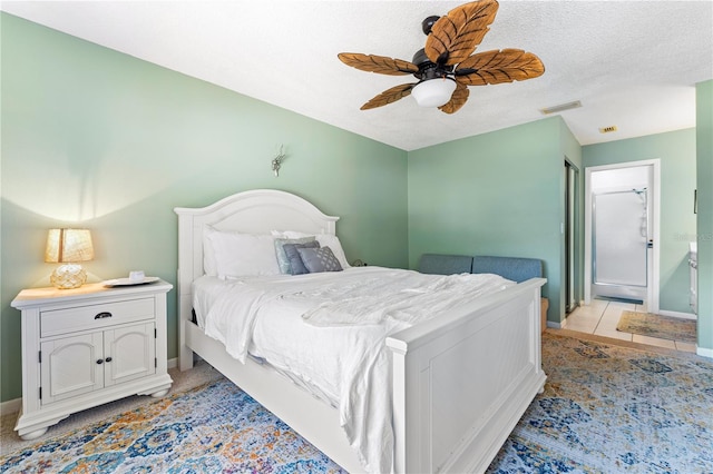 bedroom featuring a textured ceiling, ceiling fan, and light tile patterned floors