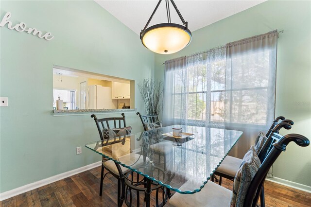 dining space featuring hardwood / wood-style flooring and vaulted ceiling