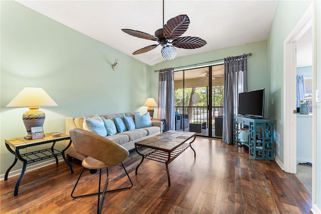 living room featuring ceiling fan and dark hardwood / wood-style flooring