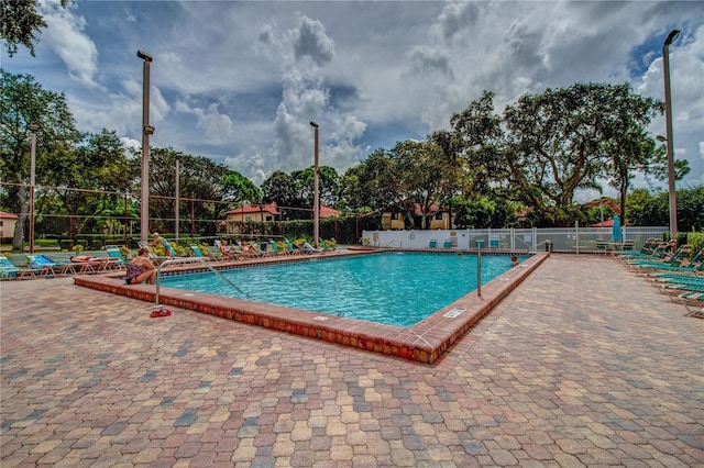 pool with fence and a patio