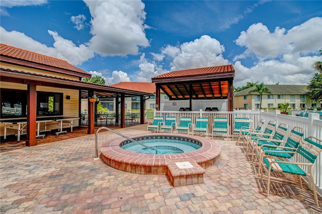 view of swimming pool featuring a patio area, fence, and a hot tub