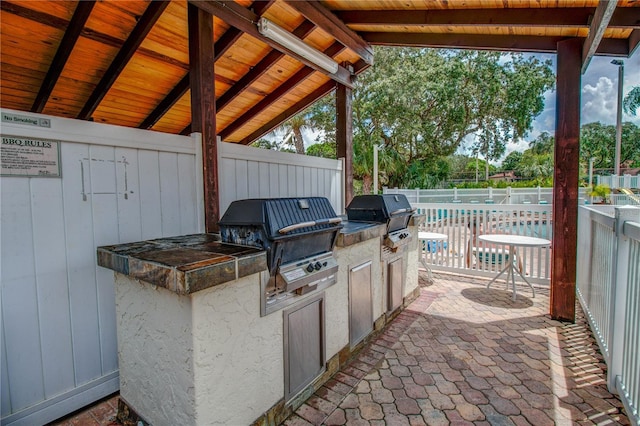 view of patio / terrace with exterior kitchen, a grill, and fence