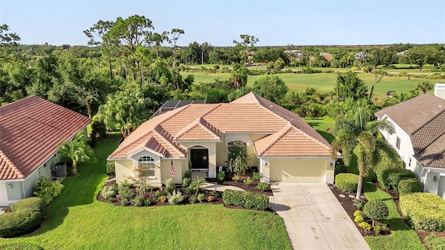 view of front of property featuring a garage, a tile roof, driveway, stucco siding, and a front lawn