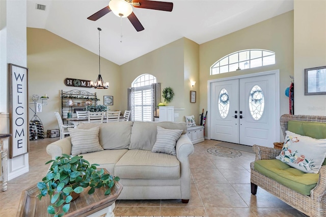 tiled living room with ceiling fan, high vaulted ceiling, and plenty of natural light