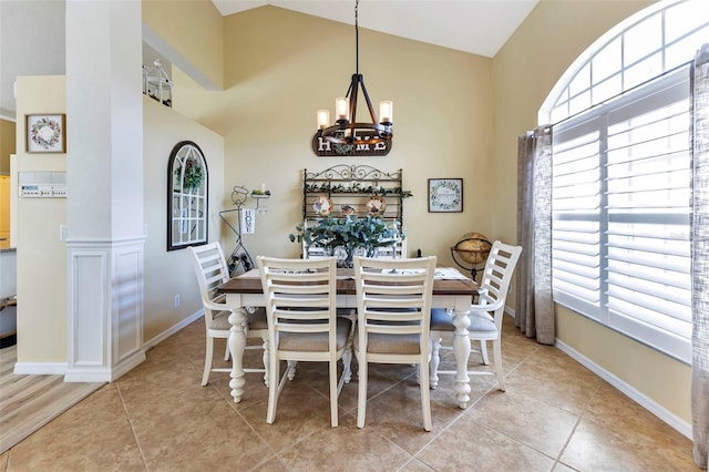 tiled dining room with high vaulted ceiling and a notable chandelier