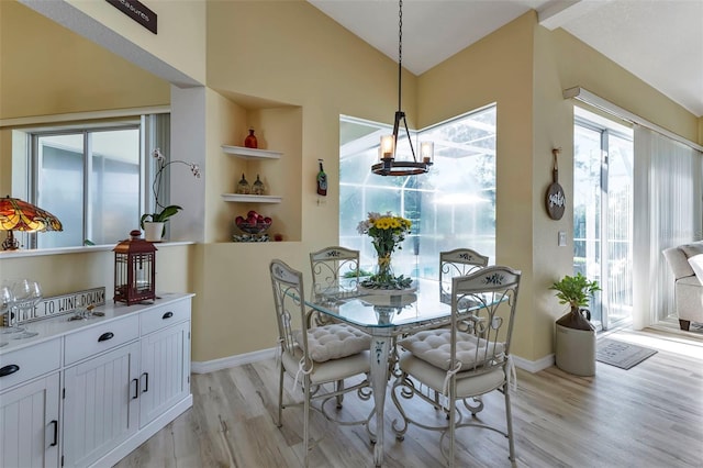 dining area featuring a notable chandelier, light wood-type flooring, and built in features