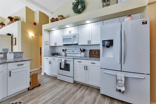 kitchen featuring light wood-type flooring, tasteful backsplash, white appliances, and white cabinetry